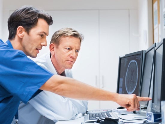 Physicians pointing to an xray image on a computer