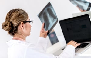 Doctor working at the hospital on a laptop and holding x-ray