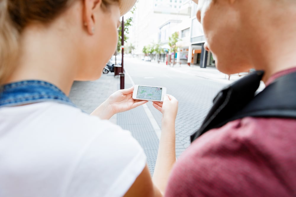 Tourists using navigation app on the mobile phone.